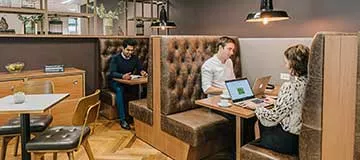 Servcorp clients collaborating in a stylish coworking lounge with premium interiors .